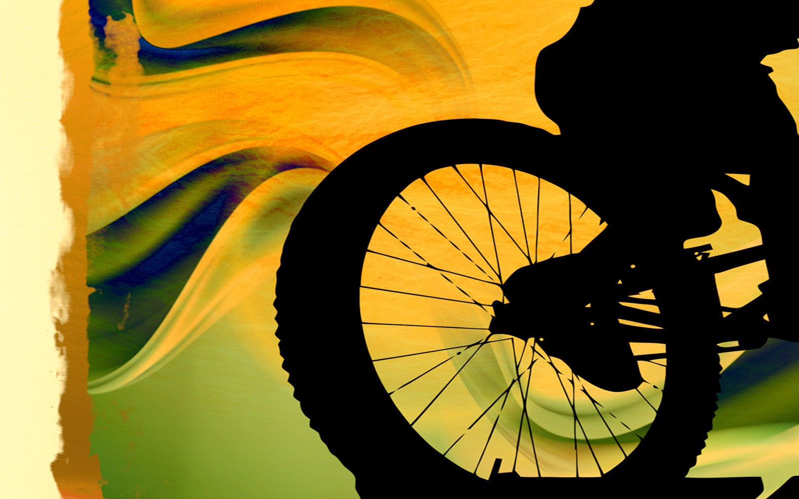 Black silhouette of back wheel of mountain bike and biker against artistic background